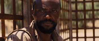 Movie still from “Django Unchained” (2012), directed by Quentin Tarantino – A person with a beard looking at the camera; Close Up shot, High angle