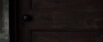 Movie still from “Django Unchained” (2012), directed by Quentin Tarantino – A dark wooden door with peeling paint on it; Extreme Close Up shot, Overhead angle