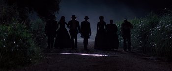 Movie still from “Django Unchained” (2012), directed by Quentin Tarantino – A group of people standing on a dirt road at night; Wide shot, Low angle