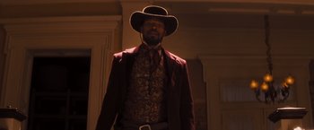 Movie still from “Django Unchained” (2012), directed by Quentin Tarantino – A man wearing a cowboy hat and a red jacket; Medium shot, Low angle