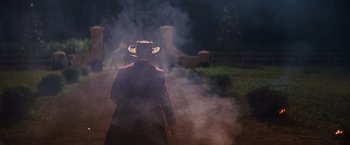 Movie still from “Django Unchained” (2012), directed by Quentin Tarantino – A man in a cowboy hat walking through smoke; Wide shot, Over the shoulder angle