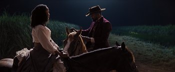 Movie still from “Django Unchained” (2012), directed by Quentin Tarantino – A man wearing a cowboy hat is riding a horse; Medium shot, Over the shoulder angle