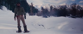 Movie still from “Django Unchained” (2012), directed by Quentin Tarantino – A person standing on a snowy slope near a forest; Wide shot, Low angle