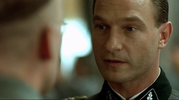 Movie still from “Downfall” (2004), directed by Oliver Hirschbiegel – A person wearing a military uniform; Close Up shot, Over the shoulder angle