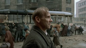 Movie still from “Downfall” (2004), directed by Oliver Hirschbiegel – A man standing in front of a group of people; Medium shot, Over the shoulder angle