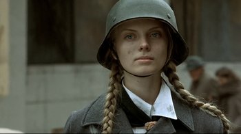 Movie still from “Downfall” (2004), directed by Oliver Hirschbiegel – A woman wearing a german helmet with long plaits; Close Up shot, Low angle