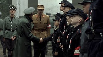 Movie still from “Downfall” (2004), directed by Oliver Hirschbiegel – A group of men in uniform shaking hands; Medium shot, Over the shoulder angle