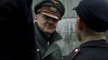 Movie still from “Downfall” (2004), directed by Oliver Hirschbiegel – An older man in a military uniform talking to a young man; Close Up shot, Over the shoulder angle