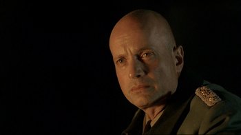 Movie still from “Downfall” (2004), directed by Oliver Hirschbiegel – A man with bald head is looking at the camera; Close Up shot, Low angle