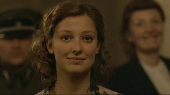 Movie still from “Downfall” (2004), directed by Oliver Hirschbiegel – A person with curly brown hair; Close Up shot, Over the shoulder angle