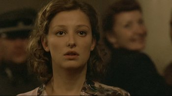Movie still from “Downfall” (2004), directed by Oliver Hirschbiegel – A young woman with curly brown hair wearing a floral shirt; Close Up shot, Over the shoulder angle
