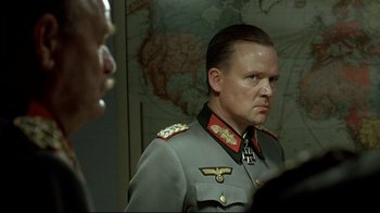 Movie still from “Downfall” (2004), directed by Oliver Hirschbiegel – A person wearing a military uniform; Close Up shot, Over the shoulder angle