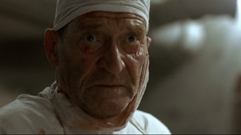 Movie still from “Downfall” (2004), directed by Oliver Hirschbiegel – An old man wearing a head band and looking at the camera; Close Up shot, Low angle