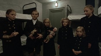 Movie still from “Downfall” (2004), directed by Oliver Hirschbiegel – A group of children standing next to each other in bunkbeds; Medium shot, High angle