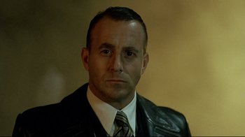 Movie still from “Downfall” (2004), directed by Oliver Hirschbiegel – A person wearing a suit and tie; Close Up shot, Low angle