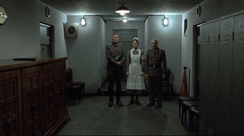 Movie still from “Downfall” (2004), directed by Oliver Hirschbiegel – A group of people standing next to each other in a room; Wide shot, Low angle
