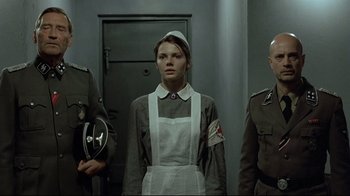 Movie still from “Downfall” (2004), directed by Oliver Hirschbiegel – A group of people standing next to each other in a room; Medium shot, Low angle