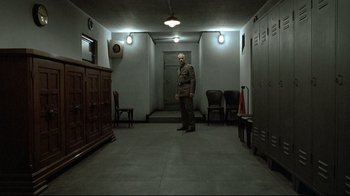 Movie still from “Downfall” (2004), directed by Oliver Hirschbiegel – A man in a uniform standing in an empty room; Wide shot, High angle