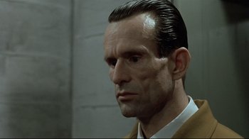 Movie still from “Downfall” (2004), directed by Oliver Hirschbiegel – A person wearing a suit and tie; Close Up shot, Low angle