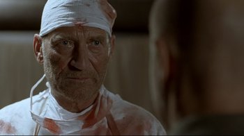 Movie still from “Downfall” (2004), directed by Oliver Hirschbiegel – An old man with a bandage on his head; Close Up shot, Over the shoulder angle