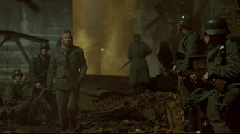 Movie still from “Downfall” (2004), directed by Oliver Hirschbiegel – A group of men standing next to each other in a building; Wide shot, Over the shoulder angle