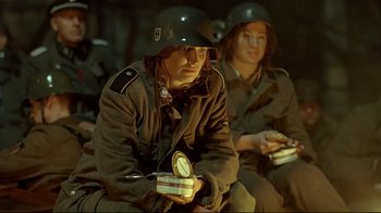 Movie still from “Downfall” (2004), directed by Oliver Hirschbiegel – A man in a military uniform holding a clock; Medium shot, Low angle
