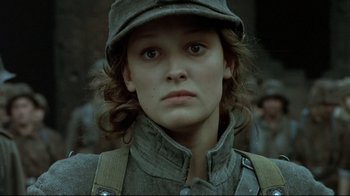 Movie still from “Downfall” (2004), directed by Oliver Hirschbiegel – A young woman in a hat is looking at the camera; Close Up shot, Low angle
