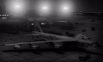 Movie still from “Dr. Strangelove or: How I Learned to Stop Worrying and Love the Bomb” (1964), directed by Stanley Kubrick – An airplane sitting on top of an airport runway; Extreme Wide shot, High angle