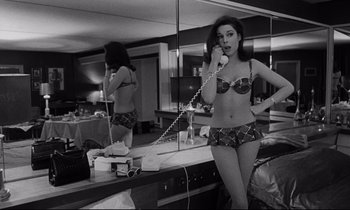 Movie still from “Dr. Strangelove or: How I Learned to Stop Worrying and Love the Bomb” (1964), directed by Stanley Kubrick – A black and white photo of a woman talking on the phone; Medium shot, High angle