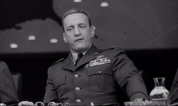 Movie still from “Dr. Strangelove or: How I Learned to Stop Worrying and Love the Bomb” (1964), directed by Stanley Kubrick – An old black and white photo of a man in uniform; Close Up shot, Low angle