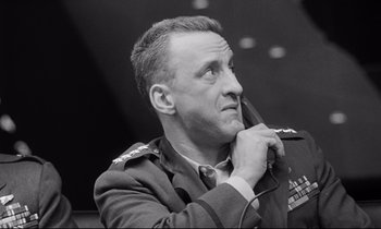 Movie still from “Dr. Strangelove or: How I Learned to Stop Worrying and Love the Bomb” (1964), directed by Stanley Kubrick – Black and white photograph of a man in military uniform; Close Up shot, Low angle