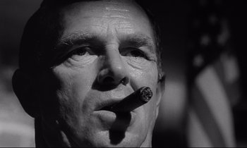 Movie still from “Dr. Strangelove or: How I Learned to Stop Worrying and Love the Bomb” (1964), directed by Stanley Kubrick – A person smoking a cigarette; Close Up shot, Low angle