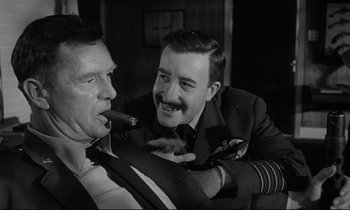 Movie still from “Dr. Strangelove or: How I Learned to Stop Worrying and Love the Bomb” (1964), directed by Stanley Kubrick – Two men are smoking a cigar and one is wearing a suit; Close Up shot, Over the shoulder angle