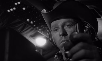 Movie still from “Dr. Strangelove or: How I Learned to Stop Worrying and Love the Bomb” (1964), directed by Stanley Kubrick – A black and white photo of a man wearing a cowboy hat; Close Up shot, Low angle