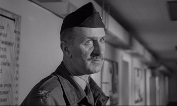 Movie still from “Dr. Strangelove or: How I Learned to Stop Worrying and Love the Bomb” (1964), directed by Stanley Kubrick – An old photo of a man in a military uniform; Close Up shot, Low angle