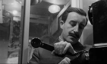 Movie still from “Dr. Strangelove or: How I Learned to Stop Worrying and Love the Bomb” (1964), directed by Stanley Kubrick – A black and white photo of a man holding a phone; Close Up shot, Low angle