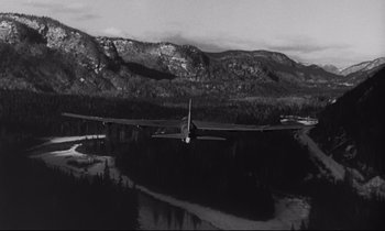 Movie still from “Dr. Strangelove or: How I Learned to Stop Worrying and Love the Bomb” (1964), directed by Stanley Kubrick – A black and white photo of a plane flying over a lake; Extreme Wide shot, High angle