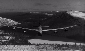 Movie still from “Dr. Strangelove or: How I Learned to Stop Worrying and Love the Bomb” (1964), directed by Stanley Kubrick – An airplane is flying over a snowy landscape; Extreme Wide shot, Low angle
