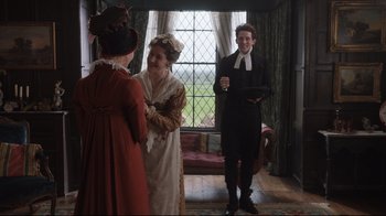 Movie still from “Emma.” (2020), directed by Autumn de Wilde – Two women and a man dressed in period clothing; Medium shot, Over the shoulder angle