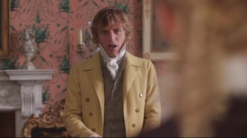 Movie still from “Emma.” (2020), directed by Autumn de Wilde – A man in a yellow jacket and a white neck tie; Medium shot, Over the shoulder angle