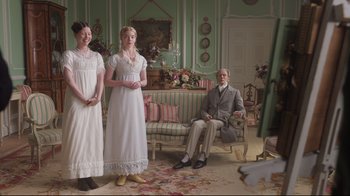 Movie still from “Emma.” (2020), directed by Autumn de Wilde – Two women and an old man in a living room; Wide shot, Low angle