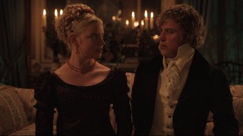 Movie still from “Emma.” (2020), directed by Autumn de Wilde – A man and a woman standing next to each other in front of candles; Medium shot, Over the shoulder angle