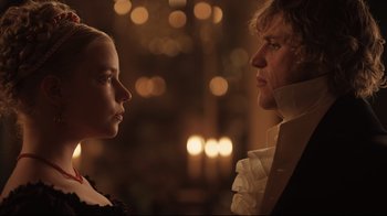Movie still from “Emma.” (2020), directed by Autumn de Wilde – A man and a woman standing next to each other in front of candles; Close Up shot, Over the shoulder angle
