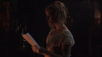 Movie still from “Emma.” (2020), directed by Autumn de Wilde – A woman in a white dress is holding a sheet of paper; Close Up shot, Over the shoulder angle