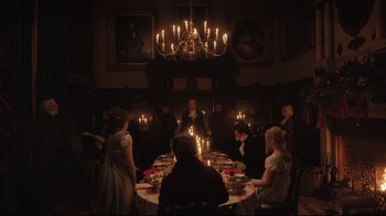 Movie still from “Emma.” (2020), directed by Autumn de Wilde – A group of people sitting around a dinner table; Wide shot, High angle