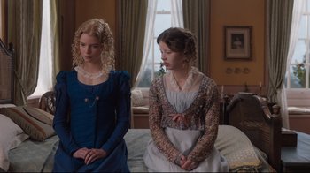 Movie still from “Emma.” (2020), directed by Autumn de Wilde – Two young women sitting on a bed in front of each other; Medium shot, Low angle