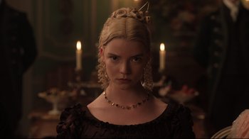 Movie still from “Emma.” (2020), directed by Autumn de Wilde – A young woman with blonde hair wearing a black dress; Close Up shot, Over the shoulder angle