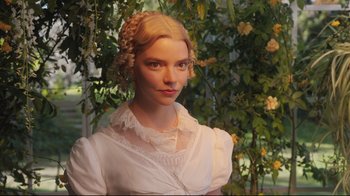 Movie still from “Emma.” (2020), directed by Autumn de Wilde – A woman in a white dress with a braid in front of a tree; Close Up shot, Low angle