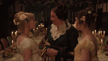 Movie still from “Emma.” (2020), directed by Autumn de Wilde – A woman and two young girls are talking to each other; Medium shot, Over the shoulder angle