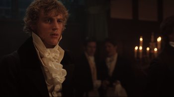 Movie still from “Emma.” (2020), directed by Autumn de Wilde – A man in a black suit standing in front of a candle; Close Up shot, Low angle